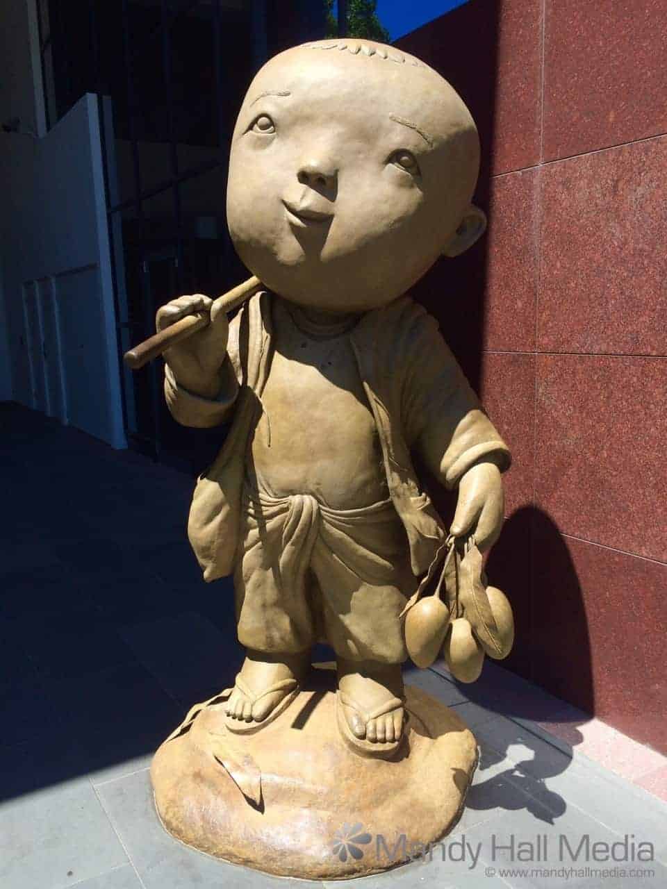 Statue of little man outside an office building