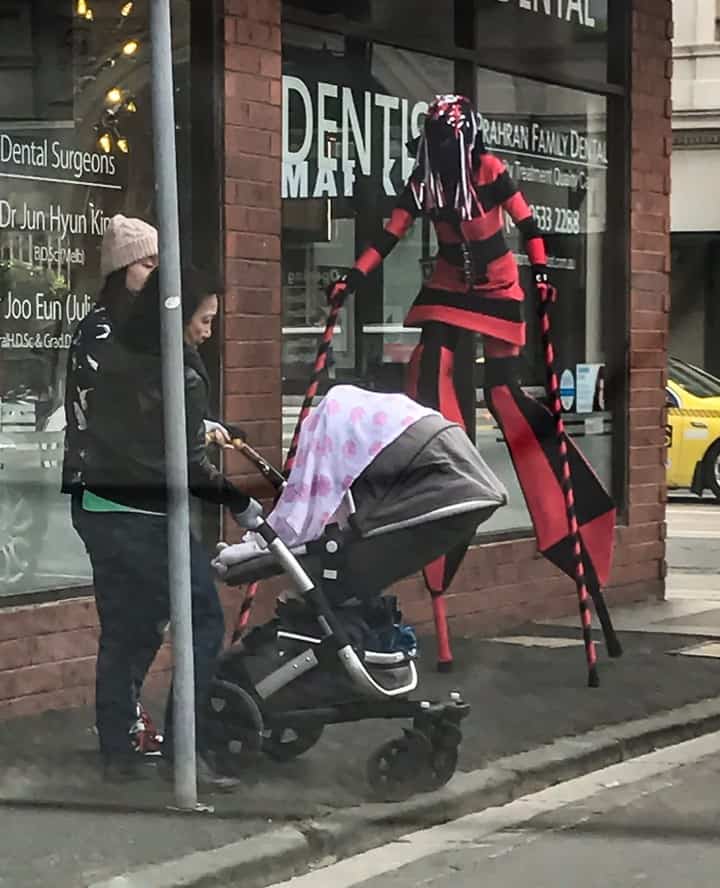 Strange spider lady on stilts in the street